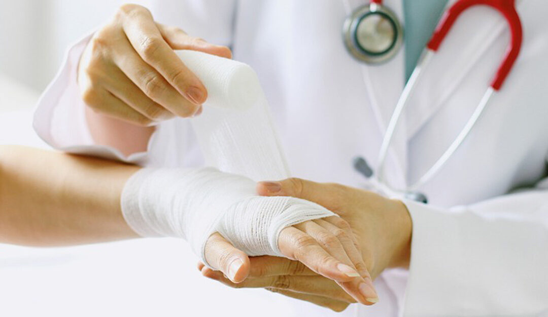 Closeup of female doctor bandaging hand of a patient