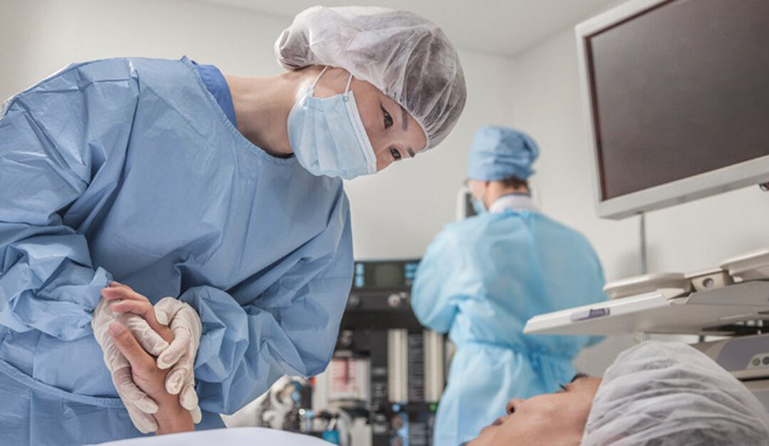 Surgeon consulting a patient, holding hands getting her prepared for surgery.