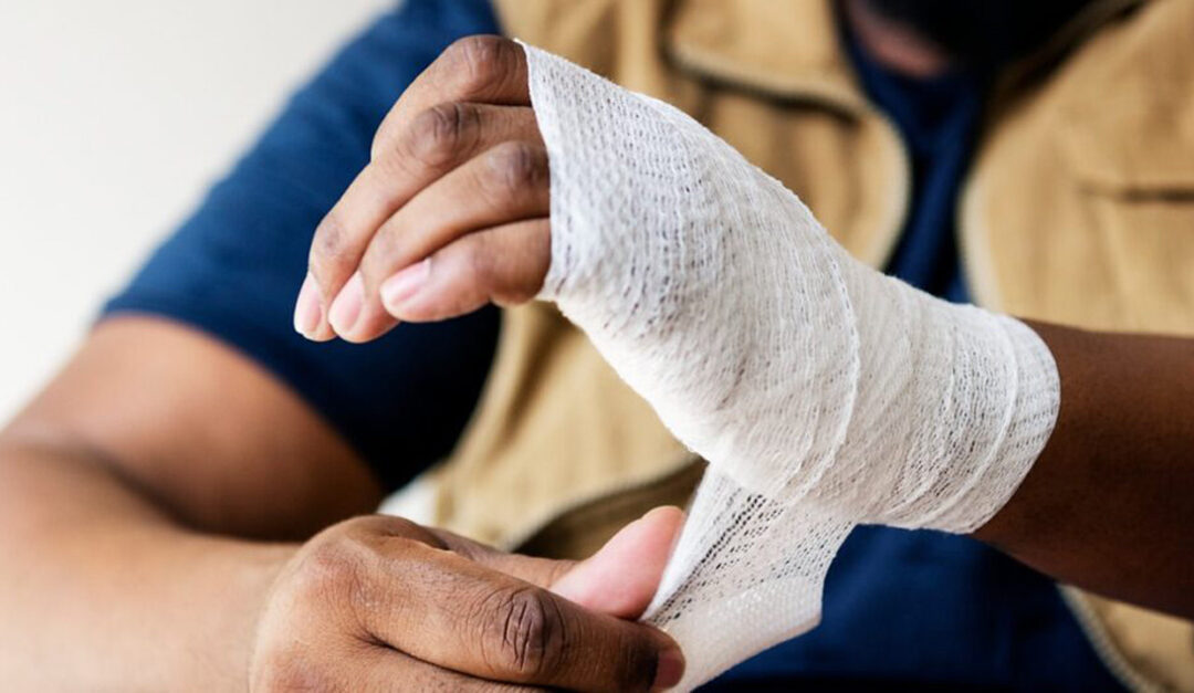 Man wrapping wounded hand