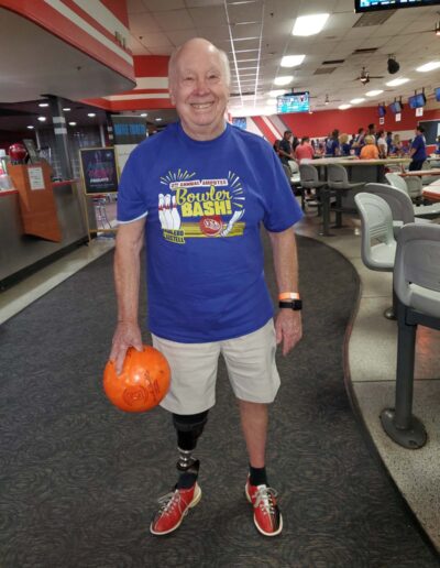 Man with prosthetic leg holding bowling ball
