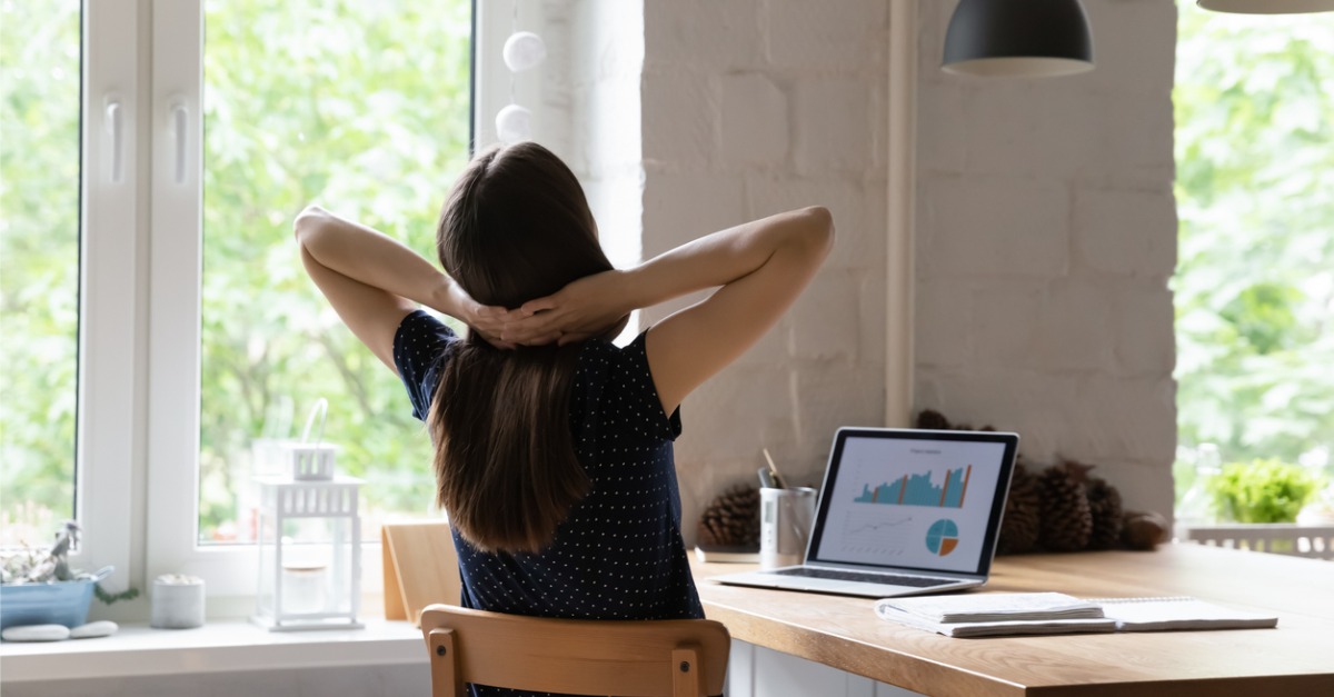 Person sitting at desk with hands on back of neck